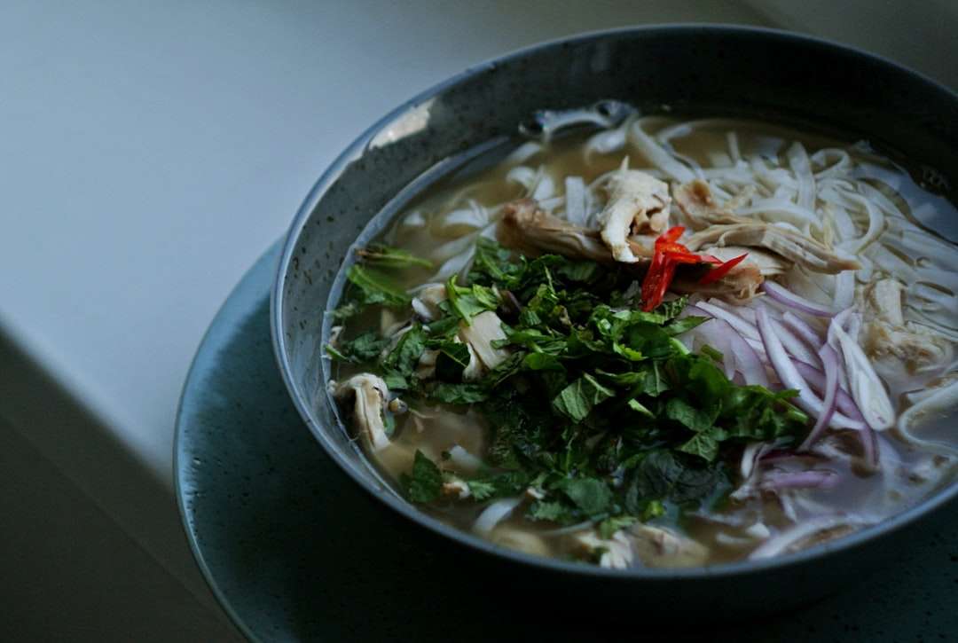 authentic-chicken-pho-recipe Bowl of authentic Vietnamese chicken pho noodle soup with fresh herbs and bean sprouts