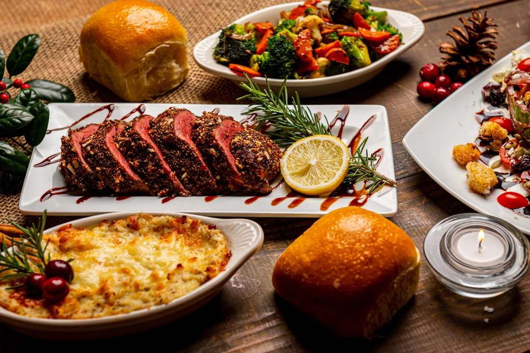 Holiday dinner table with sliced rare roast beef, potato gratin, and brioche bread.