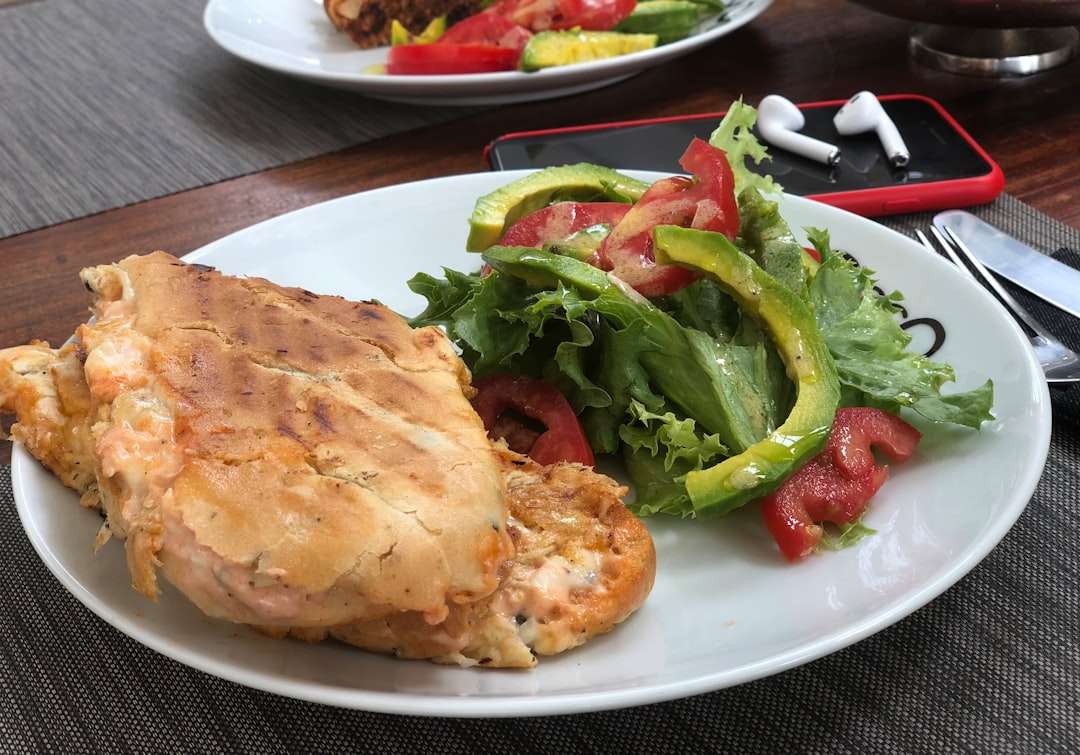 cream-cheese-bacon-stuffed-chicken Plated meal featuring a grilled panini sandwich and a green salad with tomatoes and avocado.