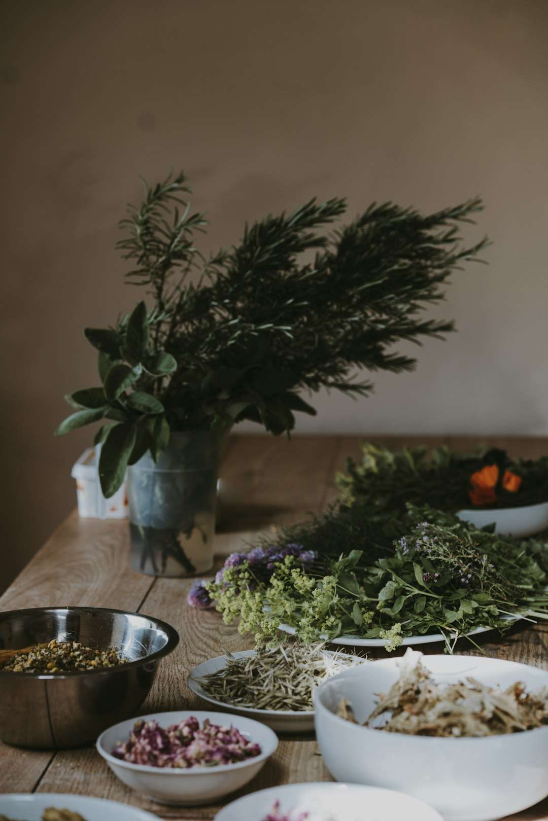 how-to-use-herbs-to-transform-any-dish A bouquet of fresh aromatic herbs and rosemary sprigs on a wooden table.