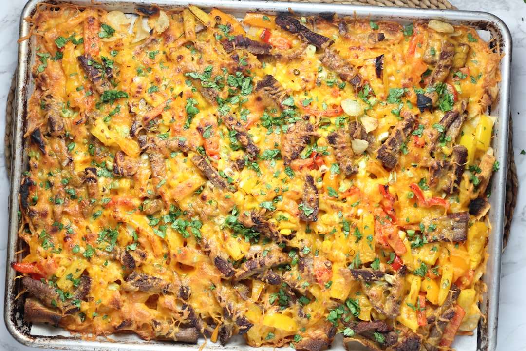 A colorful sheet pan dinner of steak fajitas with charred bell peppers and onions