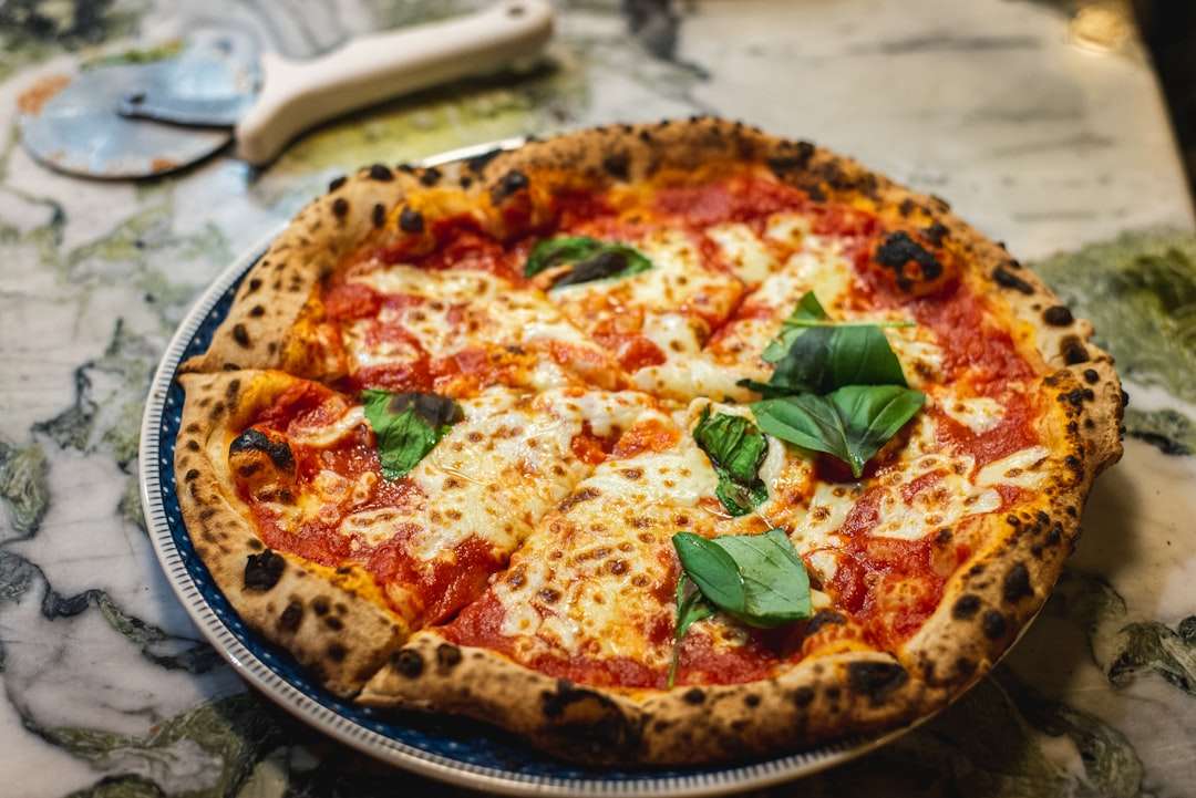 the-history-of-neapolitan-pizza Homemade Neapolitan pizza with melted mozzarella cheese, tomato sauce, and fresh basil.