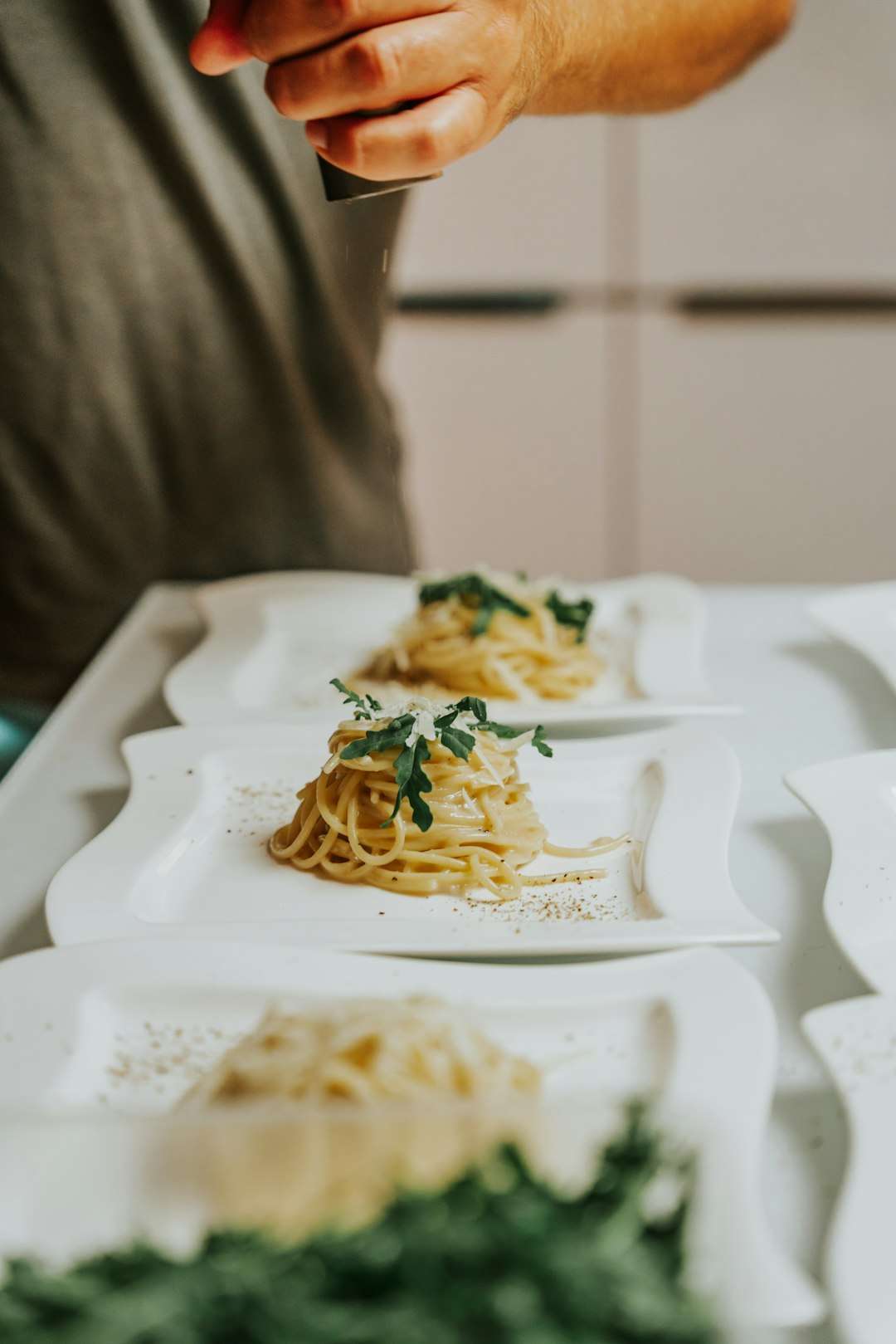 Multiple plates of spaghetti bolognese pasta ready to be served in a restaurant kitchen.