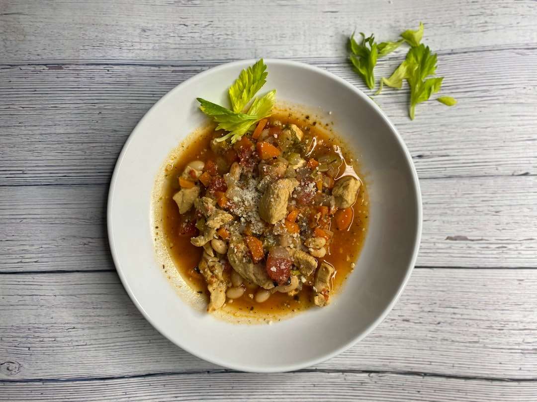 A traditional italian tamale topped with a vibrant salsa verde on a white plate