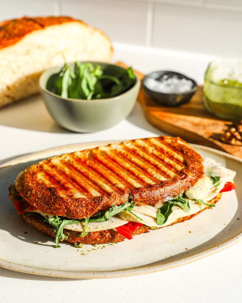 Crispy Chicken Pesto Panini (Quick Halftime Meal) Crispy chicken panini sandwich with green pesto sauce toasted on a panini press grill