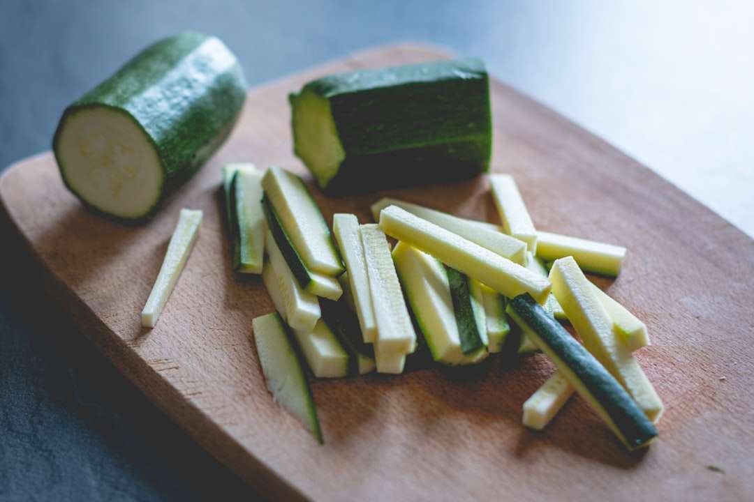 air-fryer-zucchini-fries Fresh zucchini being sliced into sticks on a wooden cutting board to make healthy zucchini fries