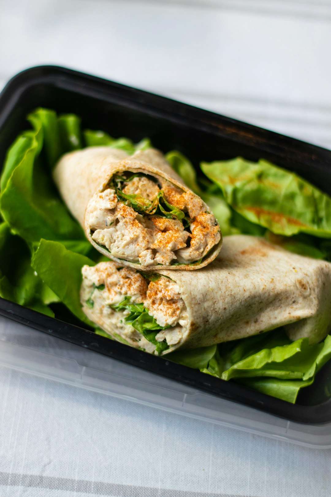 Healthy chicken Caesar wrap rolled in a flour tortilla with crisp green romaine lettuce