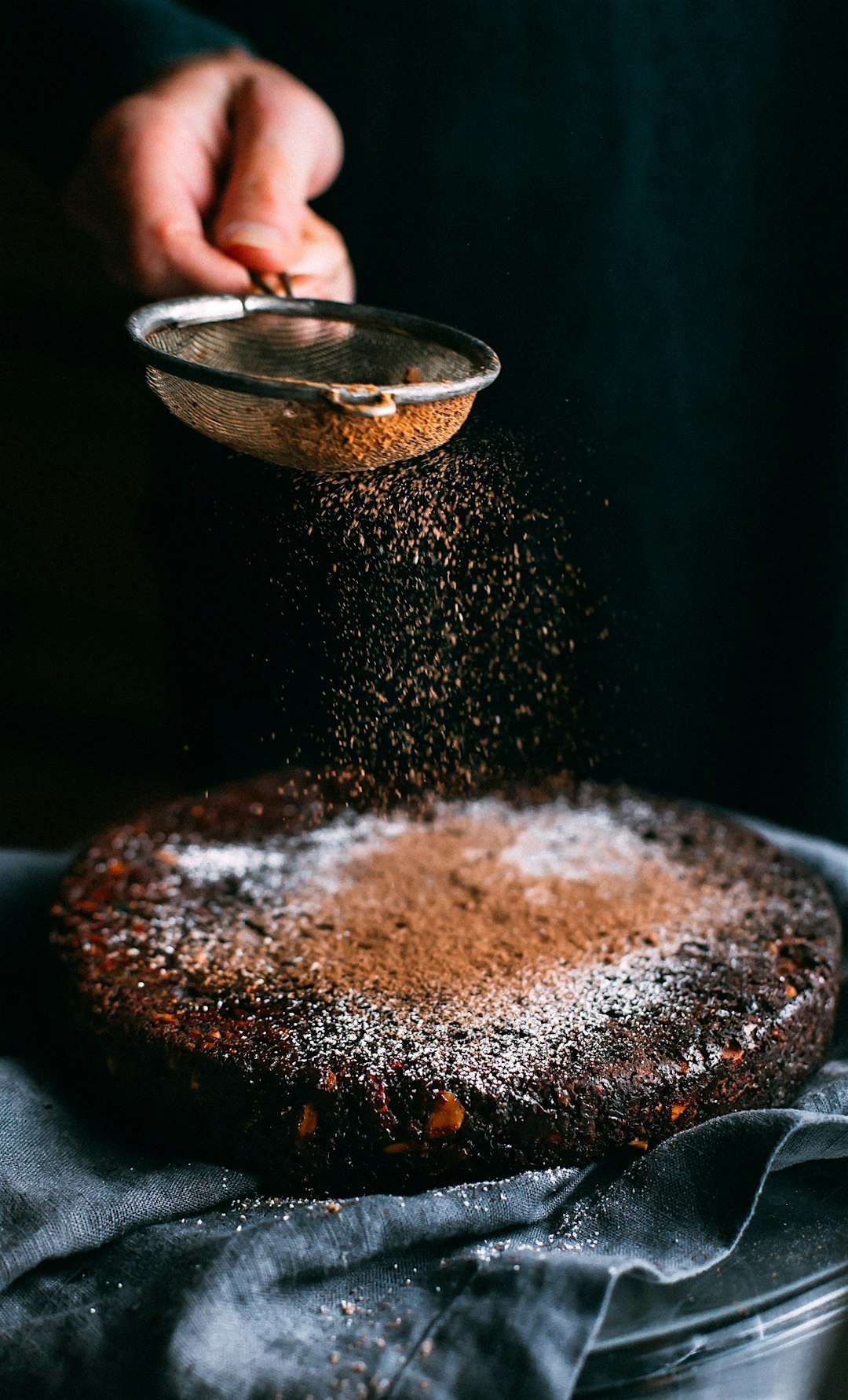 flourless-chocolate-cake Sifting powdered sugar over a rich, decadent flourless chocolate cake