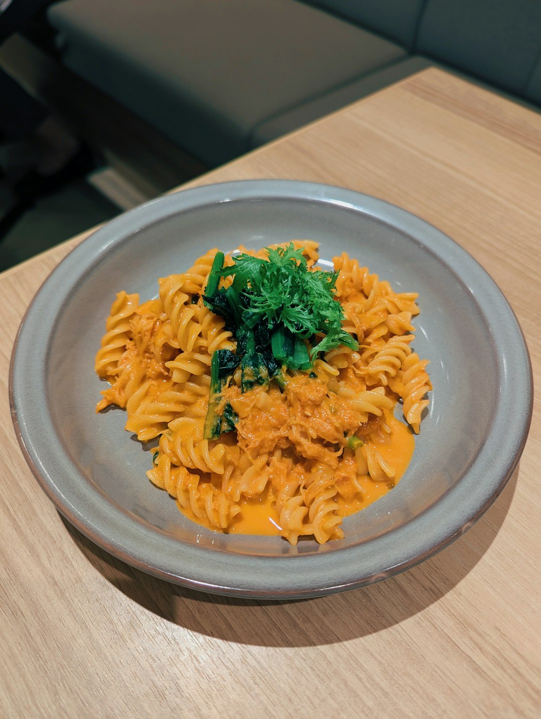 fusilli-with-creamy-pumpkin-sauce A plate of fusilli pasta coated in a creamy orange pumpkin sauce topped with fresh green herbs