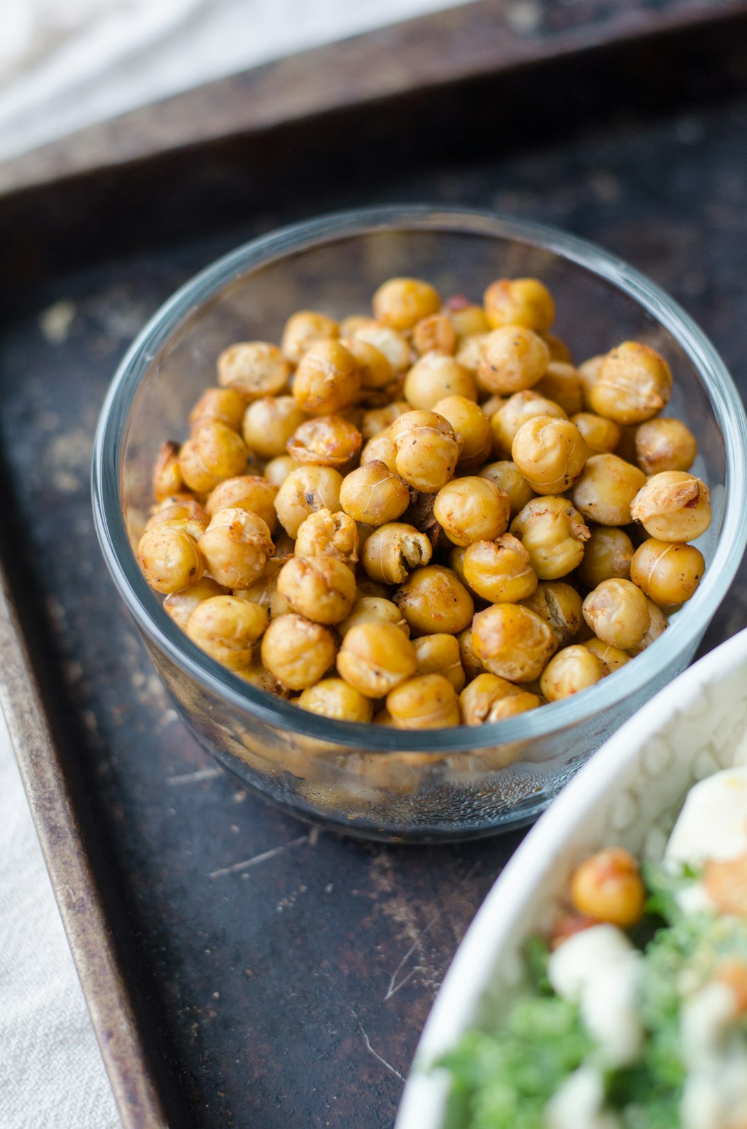 roasted-chickpeas-snacks A glass bowl filled with crispy, golden brown roasted chickpea snacks