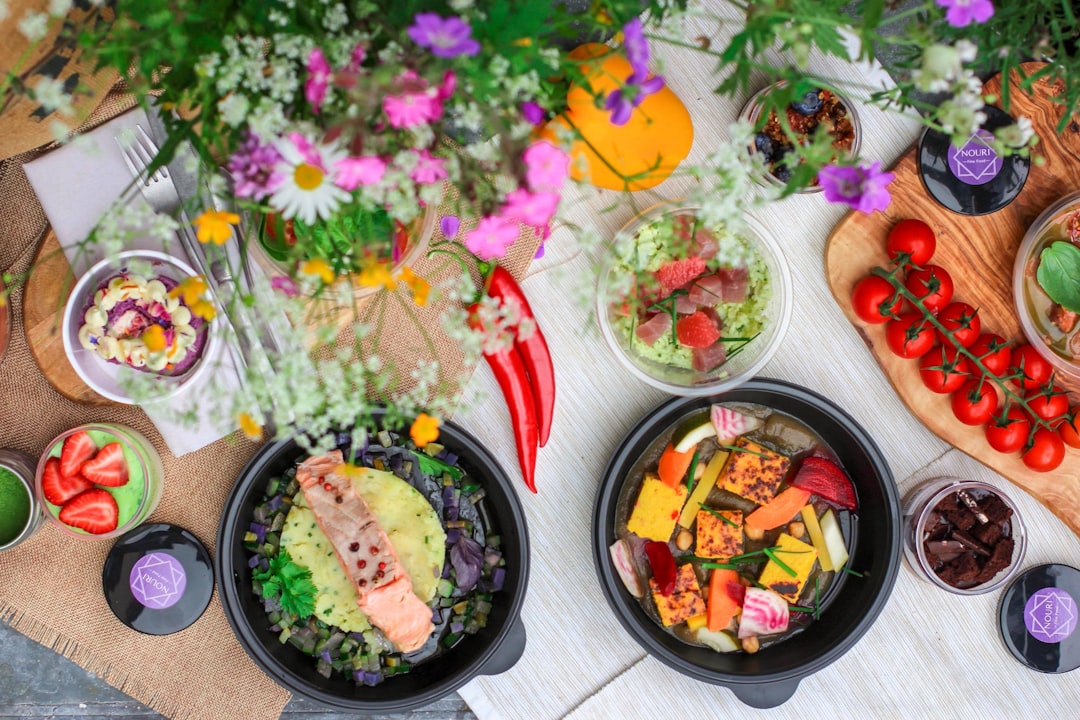summer-dishes-that-don-t-require-cooking-heat Top-down view of fresh summer dishes, vibrant salads, and colorful edible flowers spread on a table