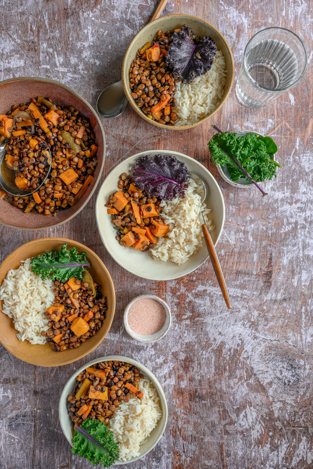 sweet-potato-and-black-bean-bowls Healthy sweet potato and black bean buddha bowls arranged on a rustic wooden tabletop