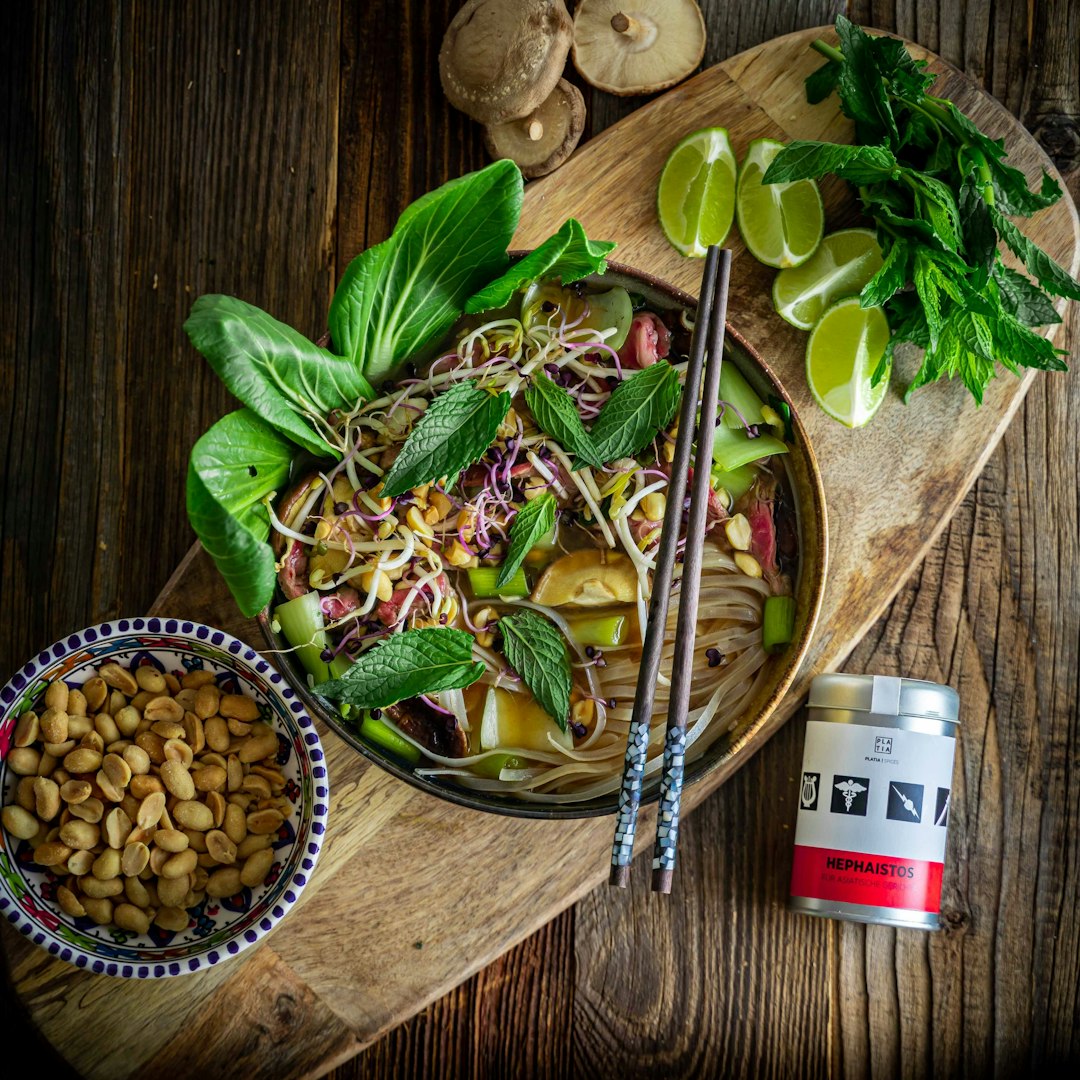 Traditional Vietnamese shaking beef (Bo Luc Lac) served with fresh greens and lime on a wooden platter